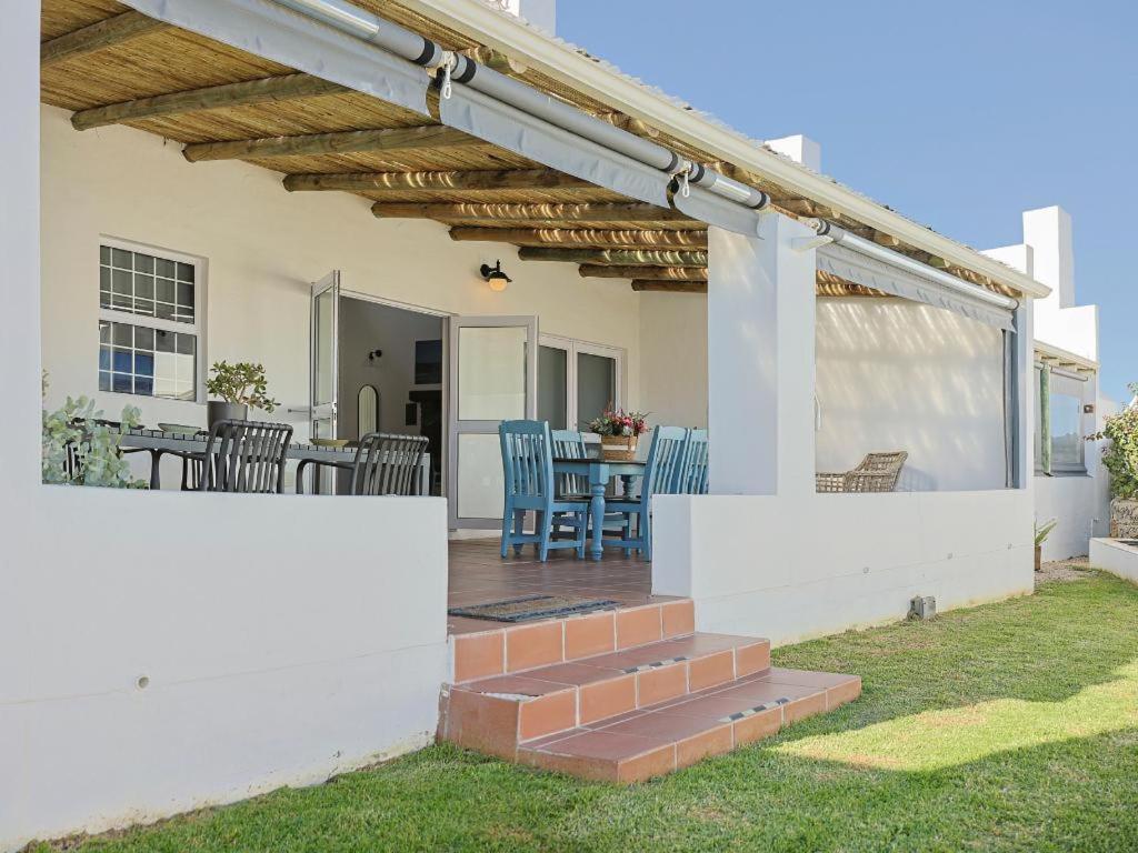a patio with chairs and a table on a house at Fijnbosch Self-Catering Units in Jacobs Bay