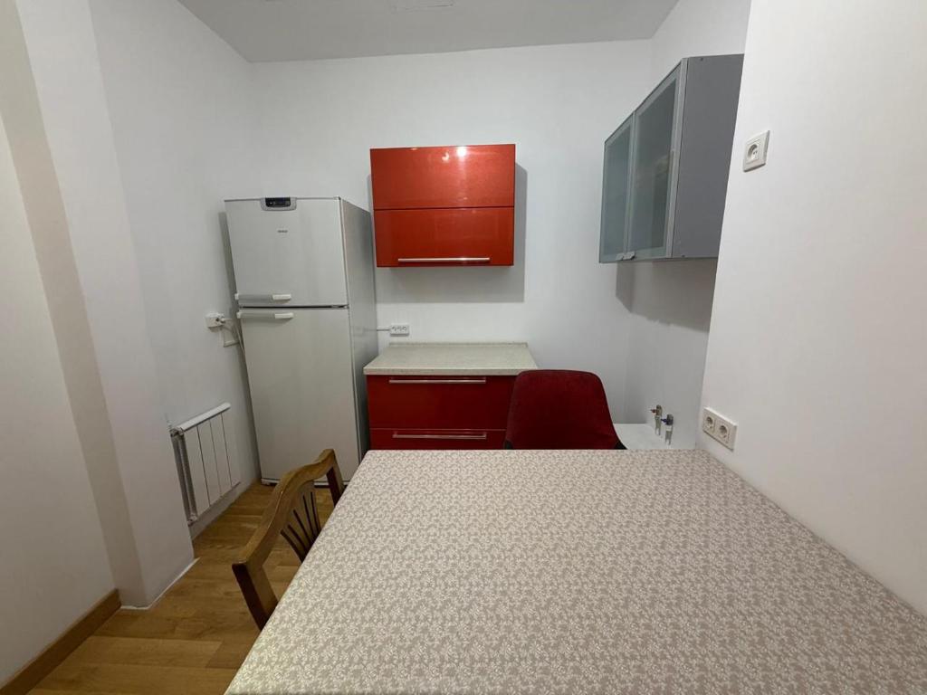 a small kitchen with a table and a refrigerator at HomeLand in Almaty