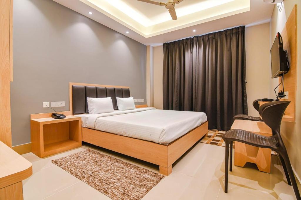 a bedroom with a bed and a desk and a television at J P Guest House in Howrah
