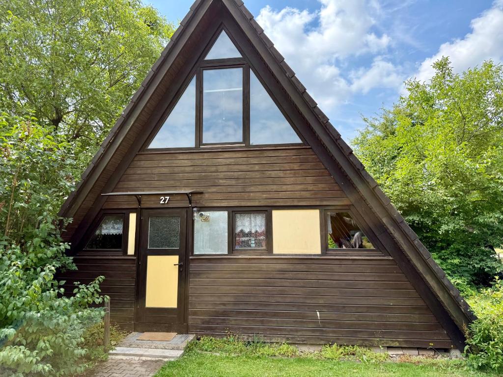 a house with a gambrel roof with a yellow door at Ferienhaus Hasenglück in Waldbrunn