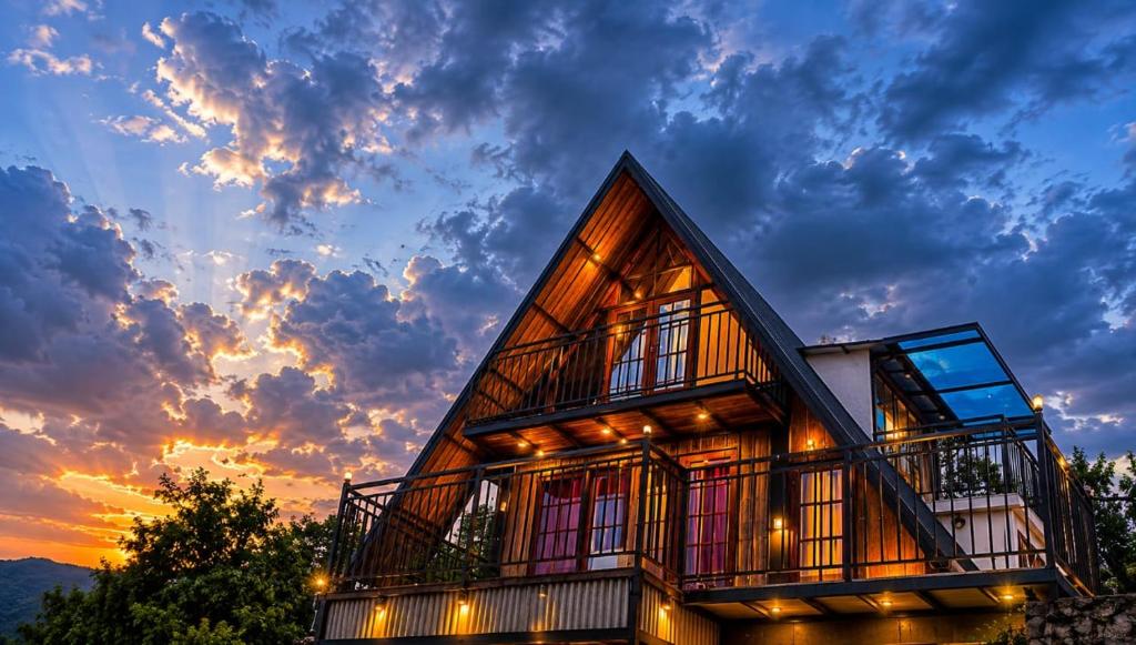 a house with a sunset in the background at Kalathil Guest House in Vagamon