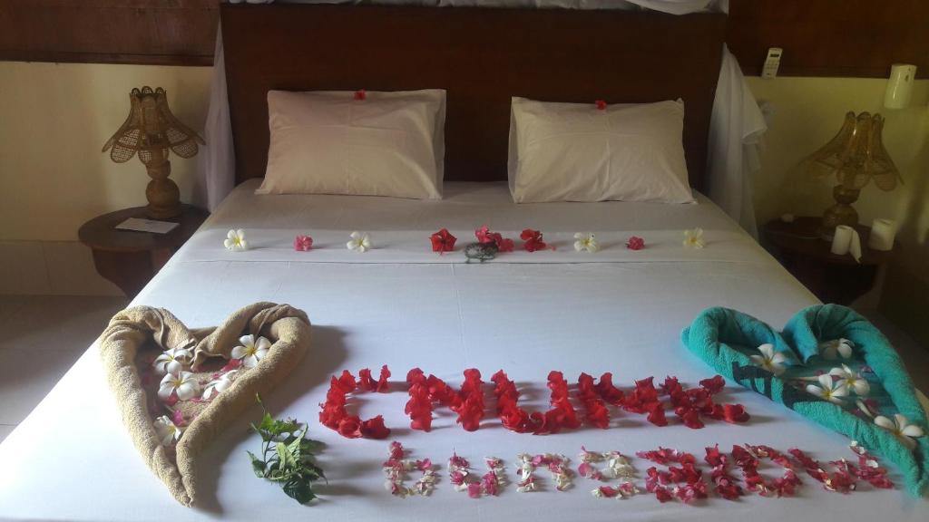 a bed with a heart shaped cake on it at Cnunk Bungalow in Gili Meno