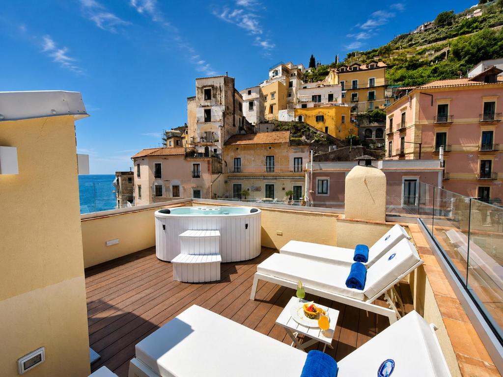 a balcony with a hot tub and a view of a city at Odisseo Apartments in Minori