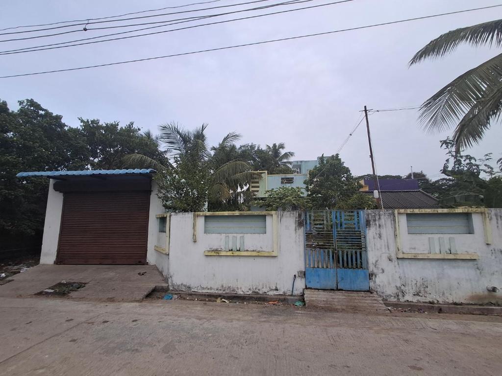 a building with a gate and a garage at Guna stay in Virāmpattinam