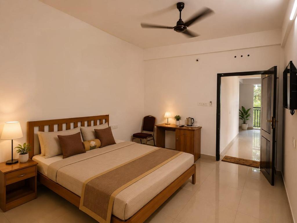 a bedroom with a bed and a ceiling fan at Uthram Avenue in Tāmarakulam