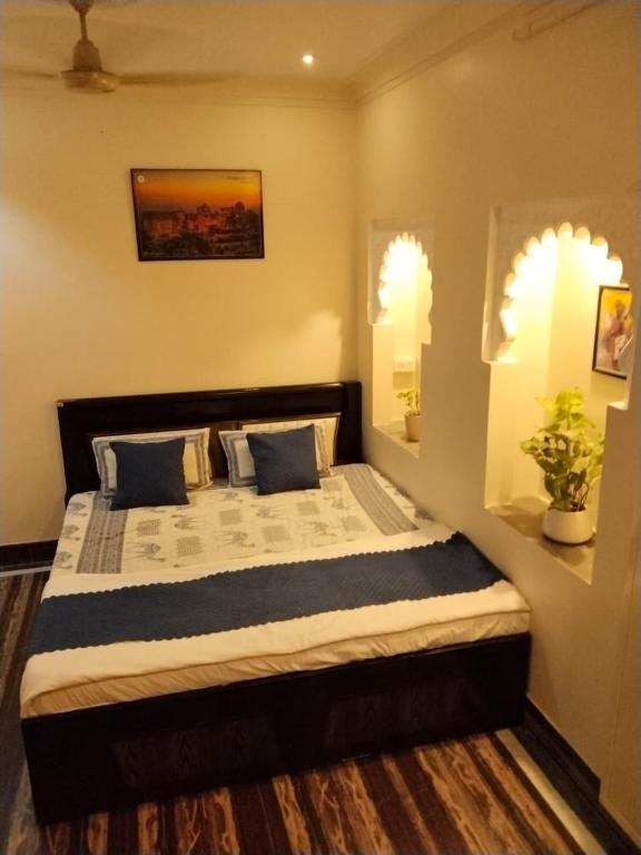 a bedroom with a large bed with blue pillows at Mahadev Bhavan in Chittaurgarh