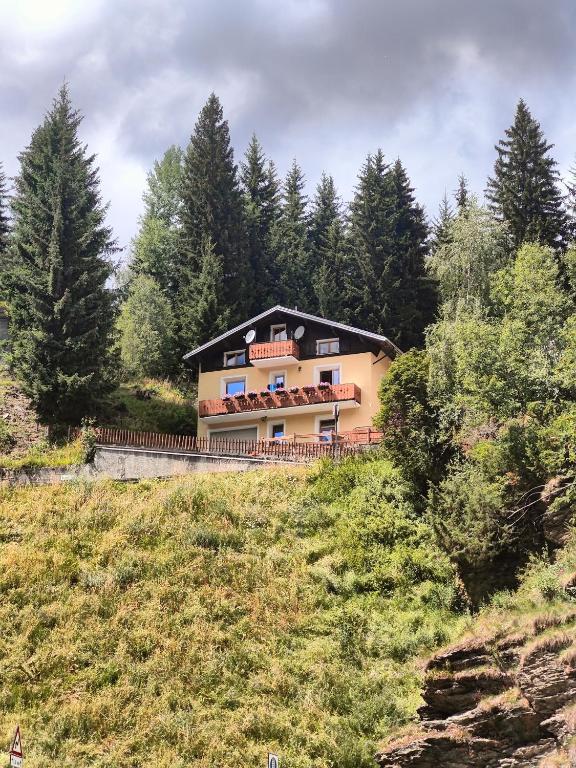 a house on the side of a hill with trees at Casa Producena in Valdidentro