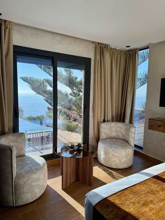 a bedroom with a bed and a table and chairs at Royal Room 5 Chambre Royale in Asilah
