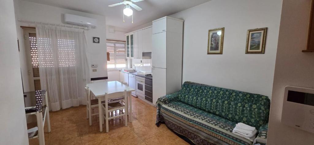 a living room with a green couch and a table at Civico 22 Guest House in Pellaro