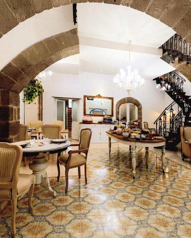 a living room with a table and chairs and a staircase at PALAZZO ALESSANDRINI GUEST HOUSE in Viterbo
