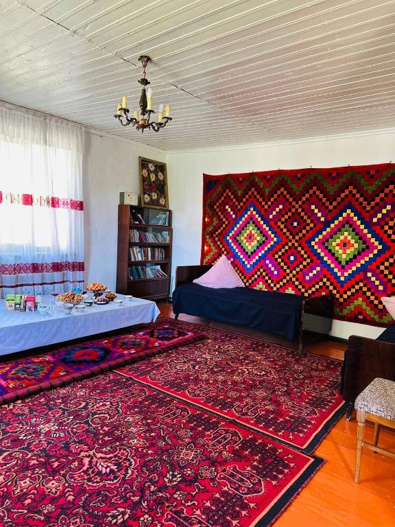 a living room with two beds and a rug at Uruyat Nomad guesthouse in Naryn