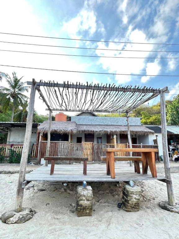 a house with a wooden porch on the beach at Pasir Homestay in Gili Gede