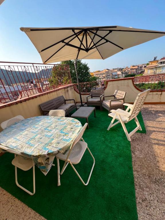 a patio with a table and chairs and an umbrella at Lavinia House in Oliveri