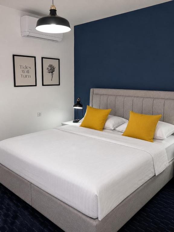 a bedroom with a large bed with yellow pillows at Apartment & Rooms Majetic-Draskovic in Bizovac