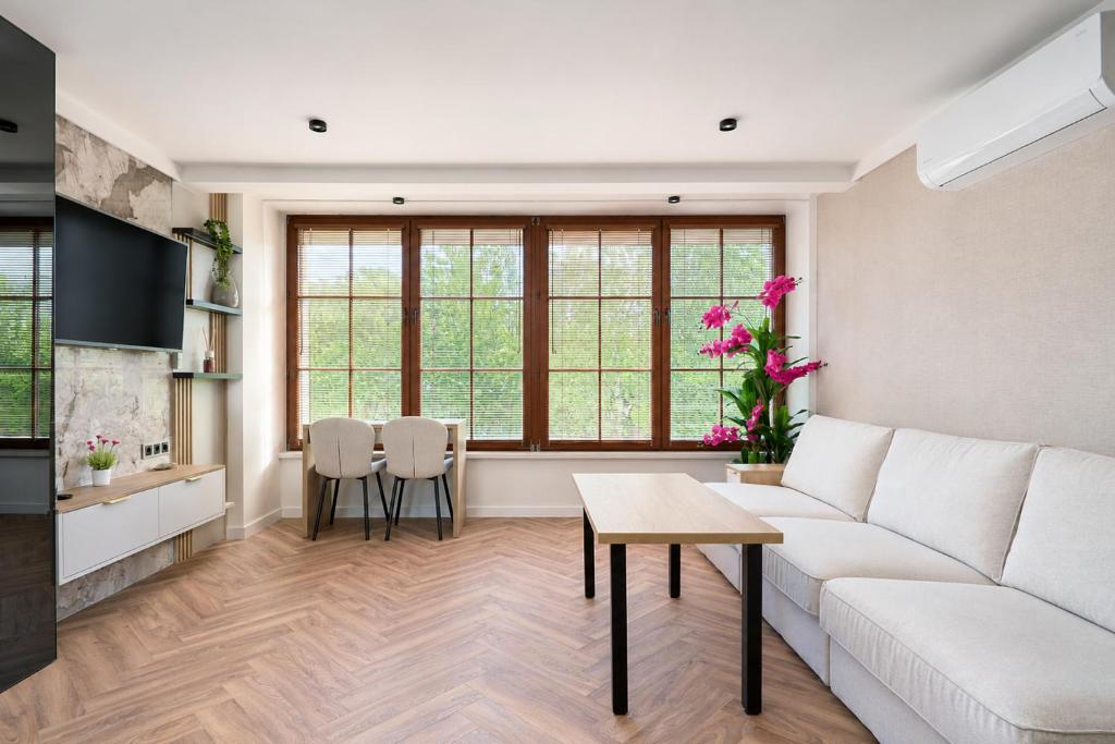 a living room with a white couch and a table at Baltic Sand - Apartamenty I Pokoje Władysławowo in Władysławowo
