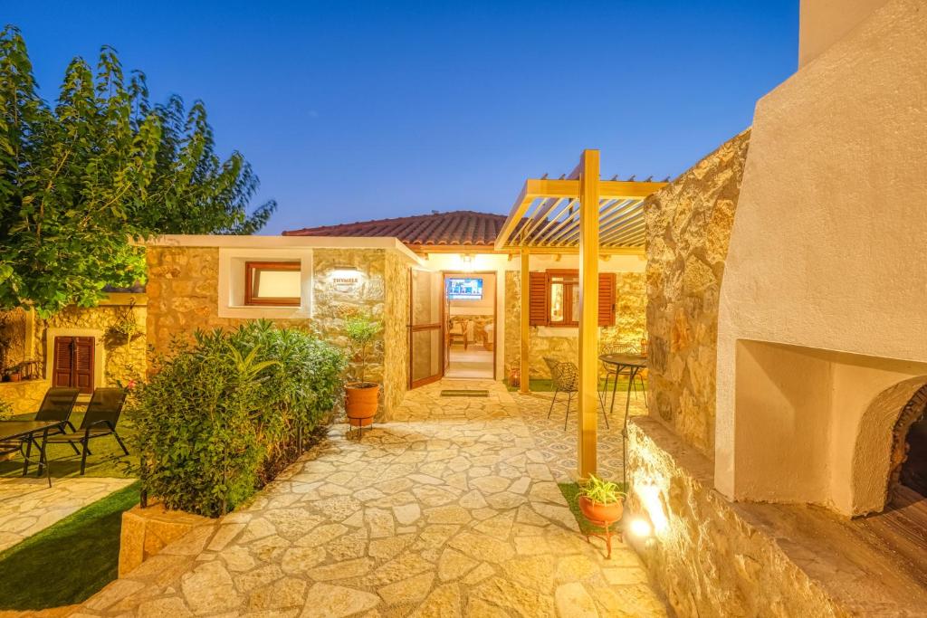 a home with a stone patio with a fireplace at Thymele Stone House in Lygourio