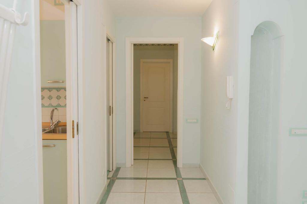 a hallway with white walls and a tile floor at gardeniapartment in Minori
