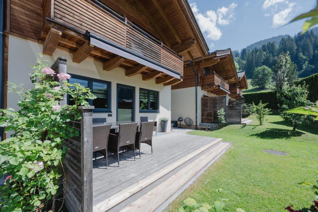 a wooden deck with chairs on a house at Chalets AurAlpin in Kleinarl