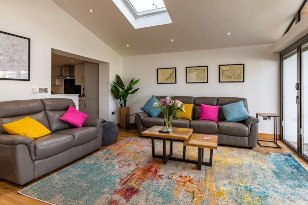 a living room with two couches and a table at Number 15 - Bude Cornwall in Bude