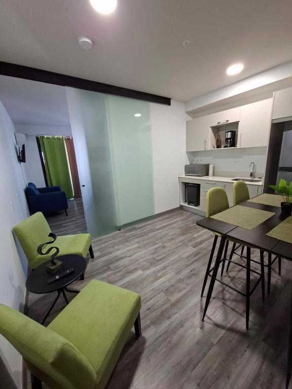 a living room with a table and chairs and a kitchen at Apartamento Moderno Cosmopolitan Tower in San José