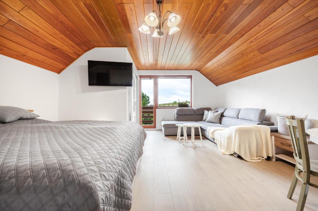 a bedroom with a bed and a couch at Apartmán Pure Harmony in Velké Bílovice