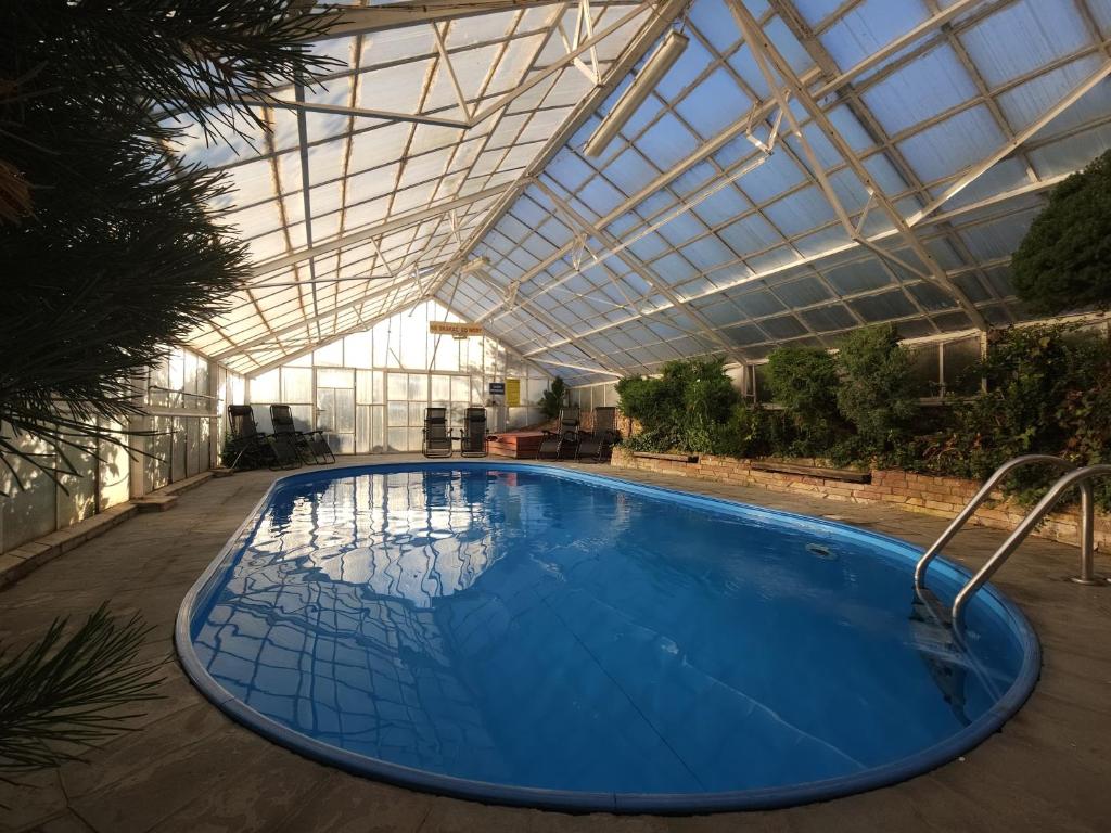 a large swimming pool in a building with a glass ceiling at Pensjonat Fluder in Jaszczurowa