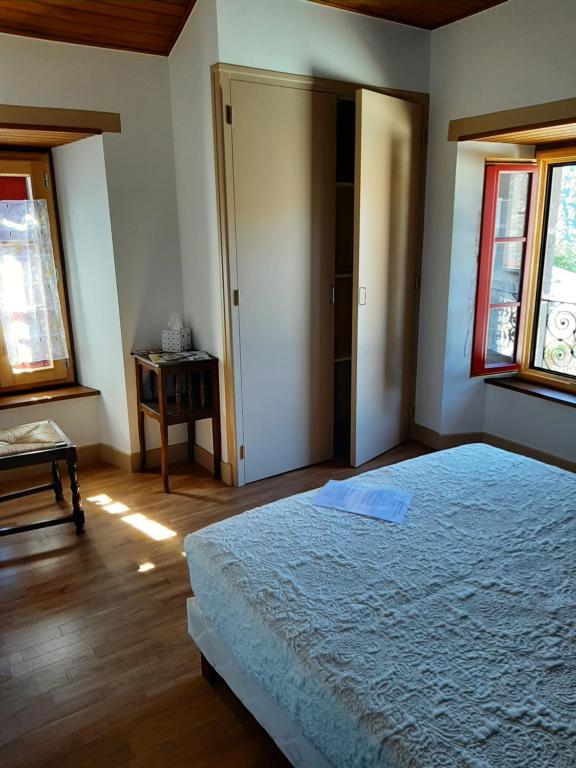 a bedroom with a bed and two windows at Auberge des Volcans in Saint-Chamant