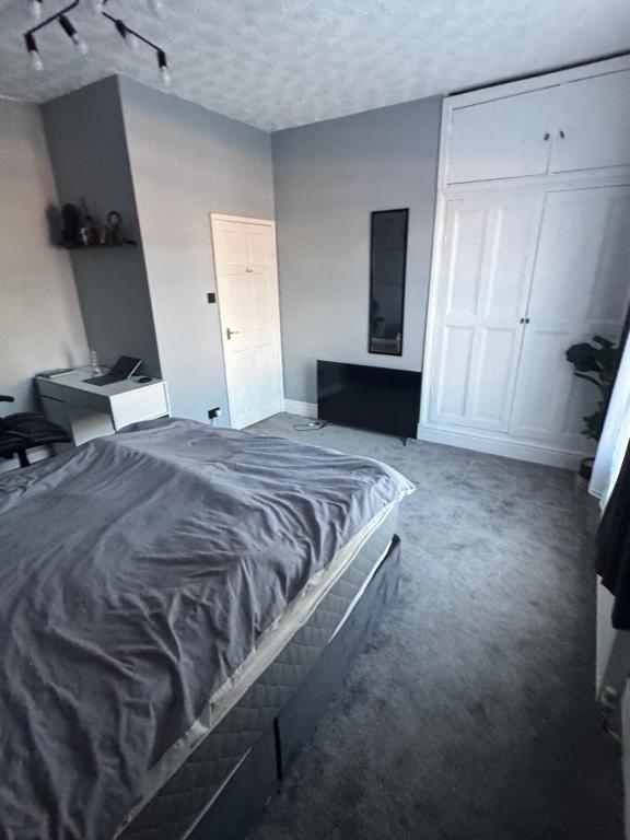 a bedroom with a large bed and a desk at Ca stays in Heywood