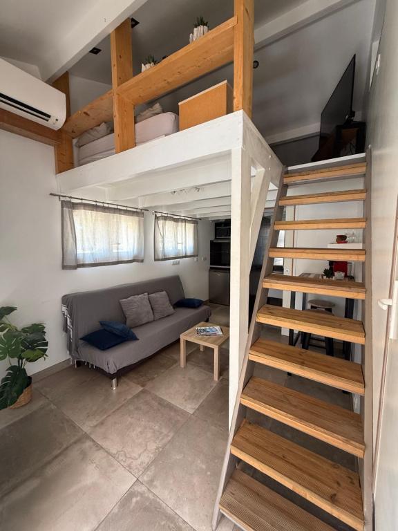 a loft bed in a living room with a couch at Petit cocon avec mezzanine in Six-Fours-les-Plages