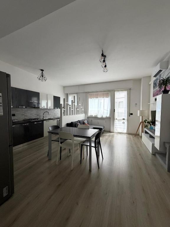 a living room with a table and a kitchen at Zuly House in Savona
