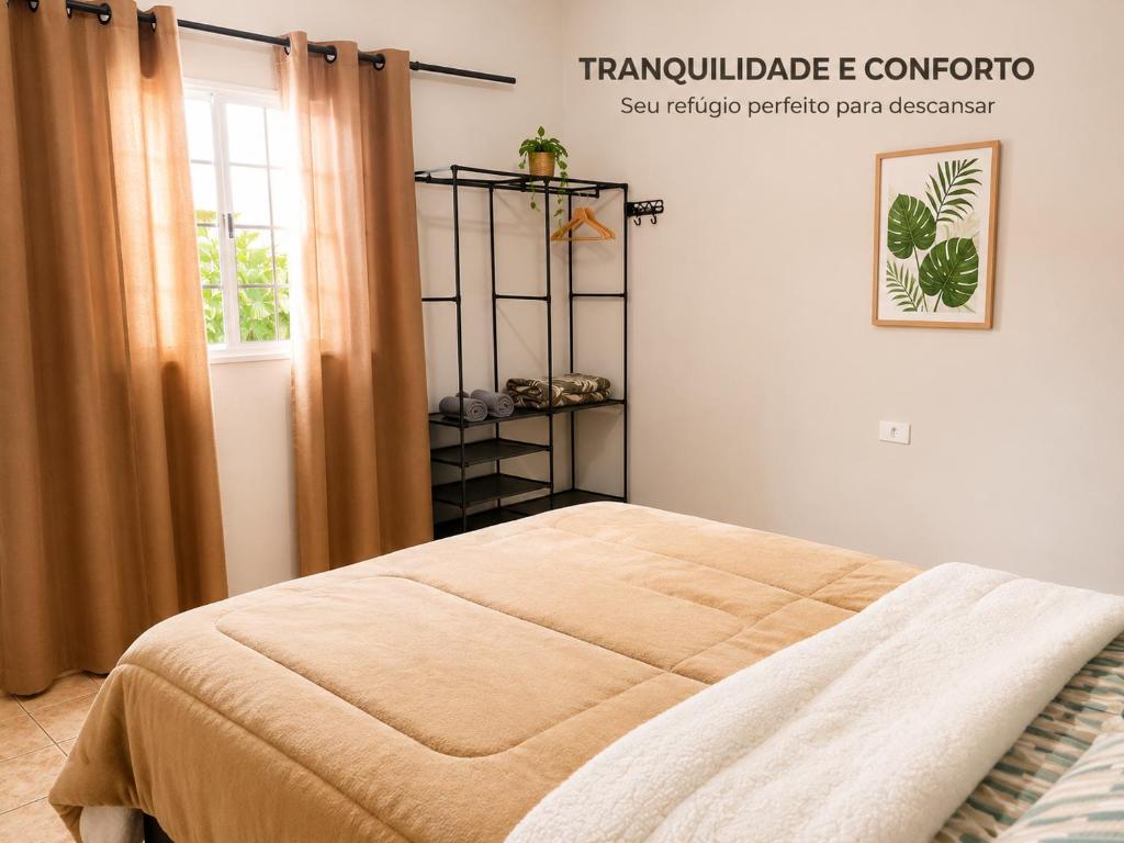 a bedroom with a bed in a room with a window at Casa do Lago in Londrina