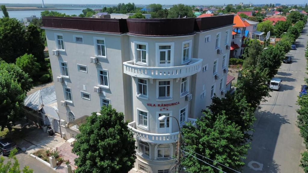 an overhead view of a large white building with trees at Vila Randunica in Eforie Sud