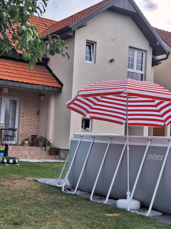 a pair of umbrellas in front of a house at Apartman ISKRA in Mataruška Banja