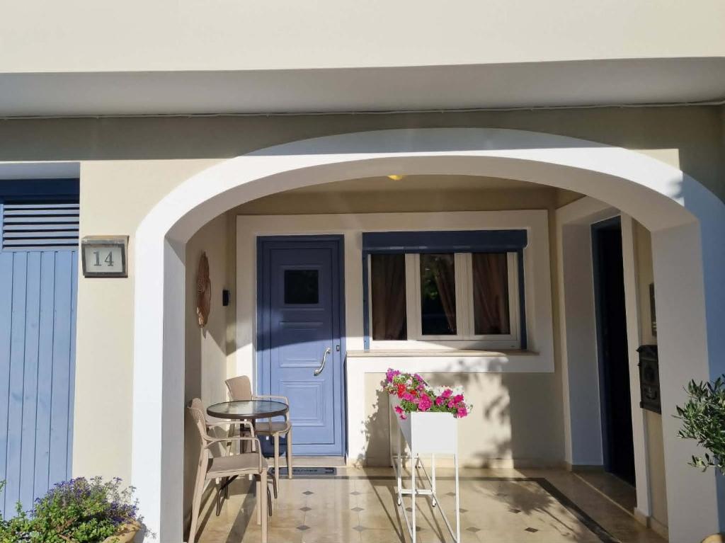 an archway leading into a house with a blue door at Menelino, next to local bus and airport station in Argostoli