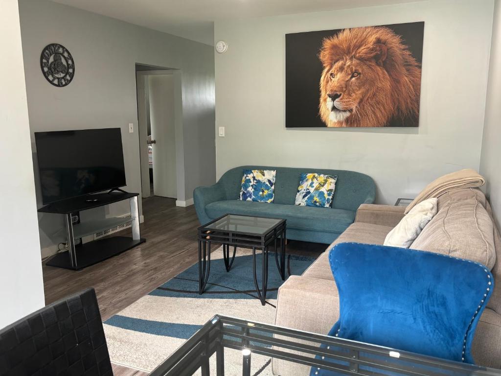 a living room with a couch and a lion on the wall at Cute Highland Park(Upper-A-Unit) in Calgary