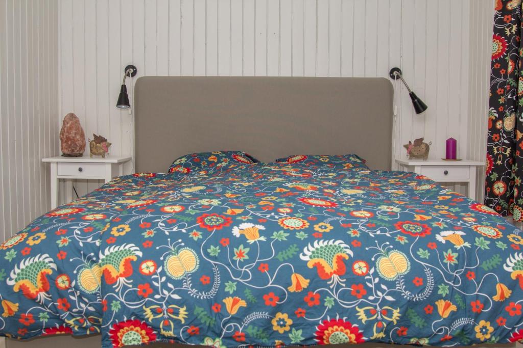 un letto con un piumone blu e fiori sopra di Kylstad Bed and Breakfast a Kylstad