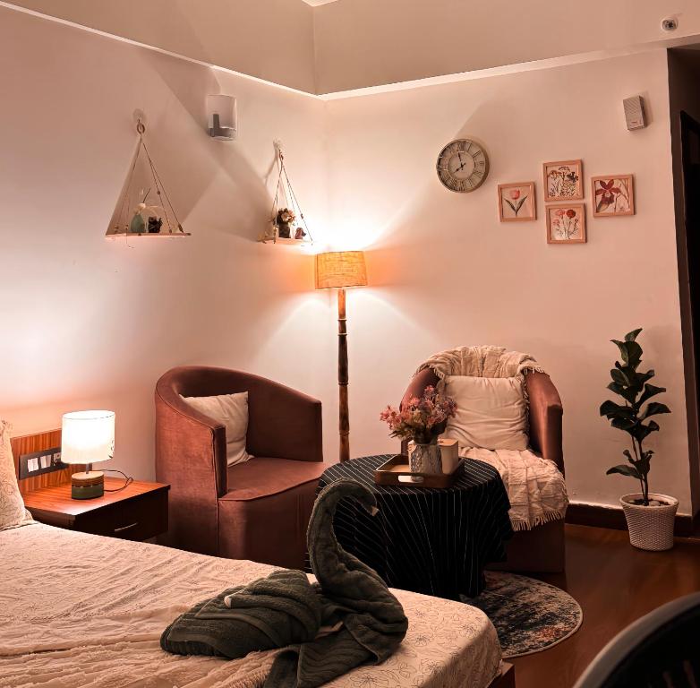 a bedroom with a bed and a chair and a table at Bs BnB Luxury Studio Apartment in Dehradun