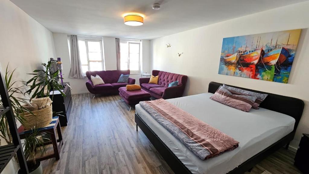 a bedroom with a bed and a living room with a couch at Studio- Gemütlich, Charmant, Zentral in Landsberg am Lech
