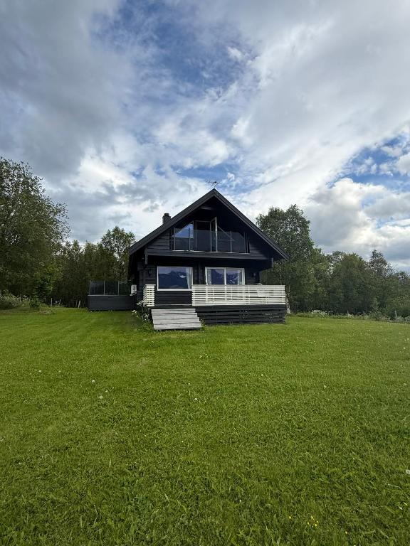 a large house on a field with a green field at Karnes Lodge in Oksevik