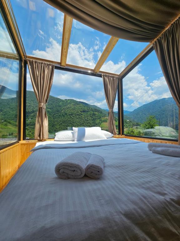 a bed in a room with a large window at Merisi Horizon in K'eda