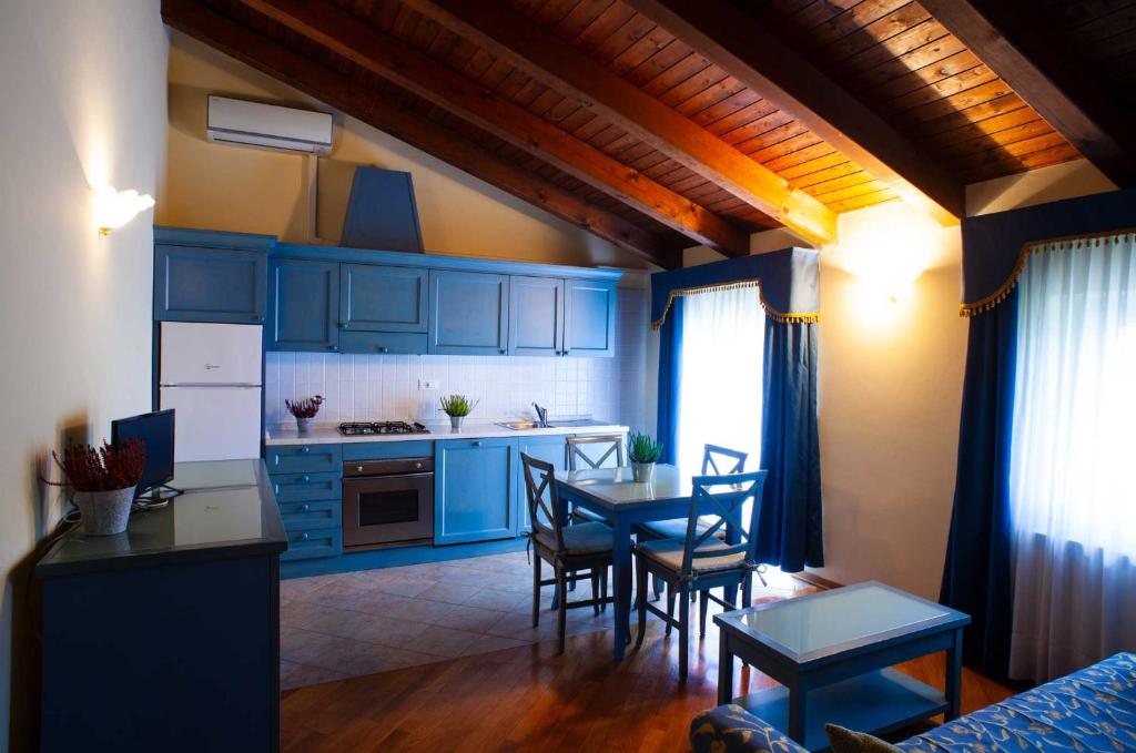 a kitchen with blue cabinets and a table and chairs at Agriturismo Hermada in Duino