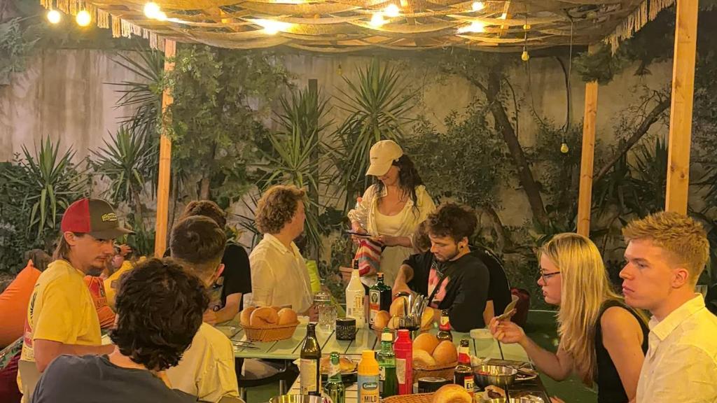 a group of people sitting at a table at a party at Balkan Hostel in Tirana