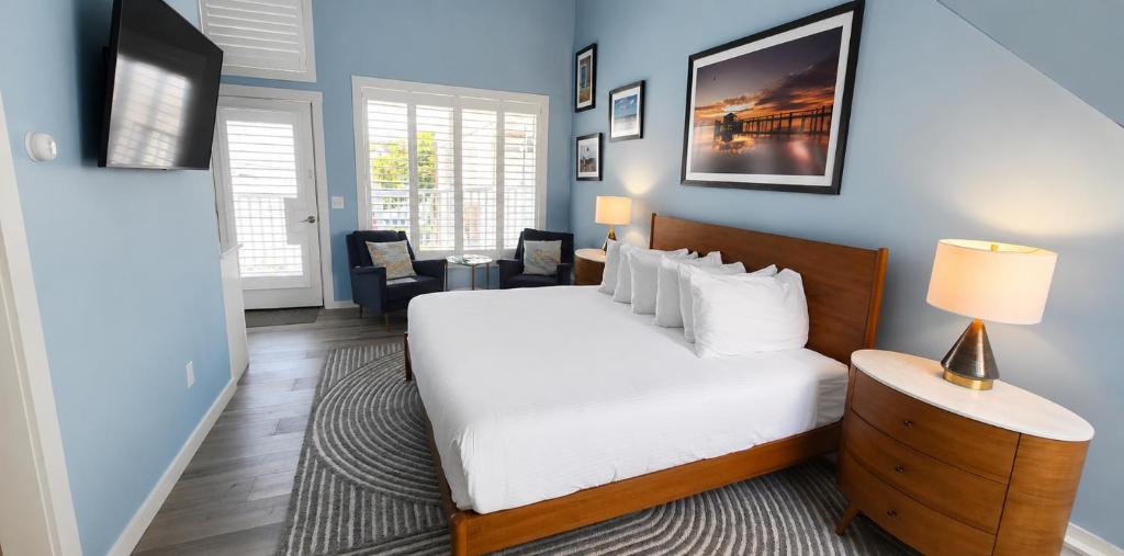 a bedroom with a white bed and a blue wall at Pilgrim House in Provincetown