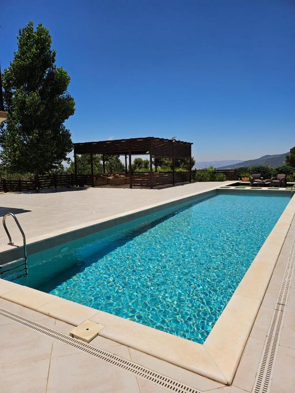 a swimming pool with a gazebo in the background at Sun farm souf in Jerash