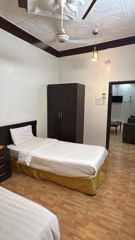 a bedroom with two beds and a ceiling at الشامخة لشقق المخدومة 2 in Sharurah