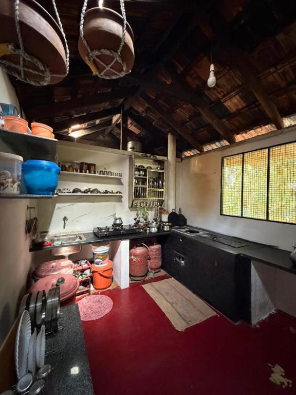 a large kitchen with a red floor in a room at Koppalu Heritage in Vastāra