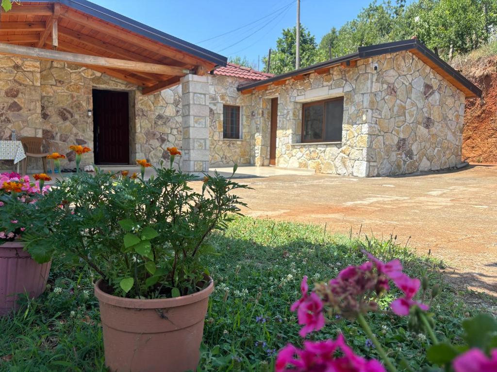 a stone house with flowers in front of it at Villa Ndoj Bukmire in Rrëshen
