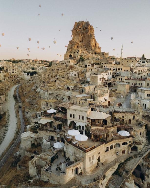 an aerial view of a village with hot air balloons at Potamia Cave Suites in Ortahisar