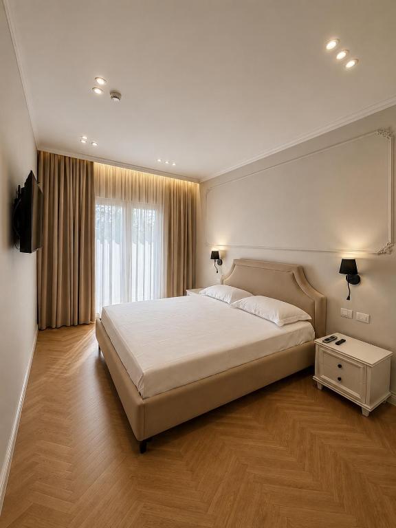 a bedroom with a large white bed and a window at Hotel Luxury Palace in Ishull-Lezhë