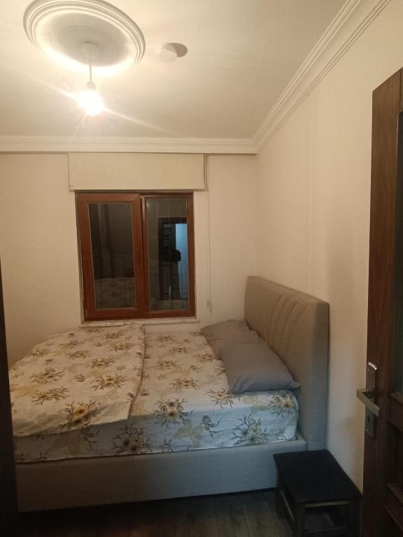 a small bedroom with a bed with a window at Deniz house apart in Güzelce